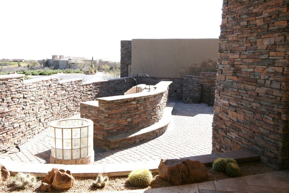 A stone wall with a brick walkway leading to it