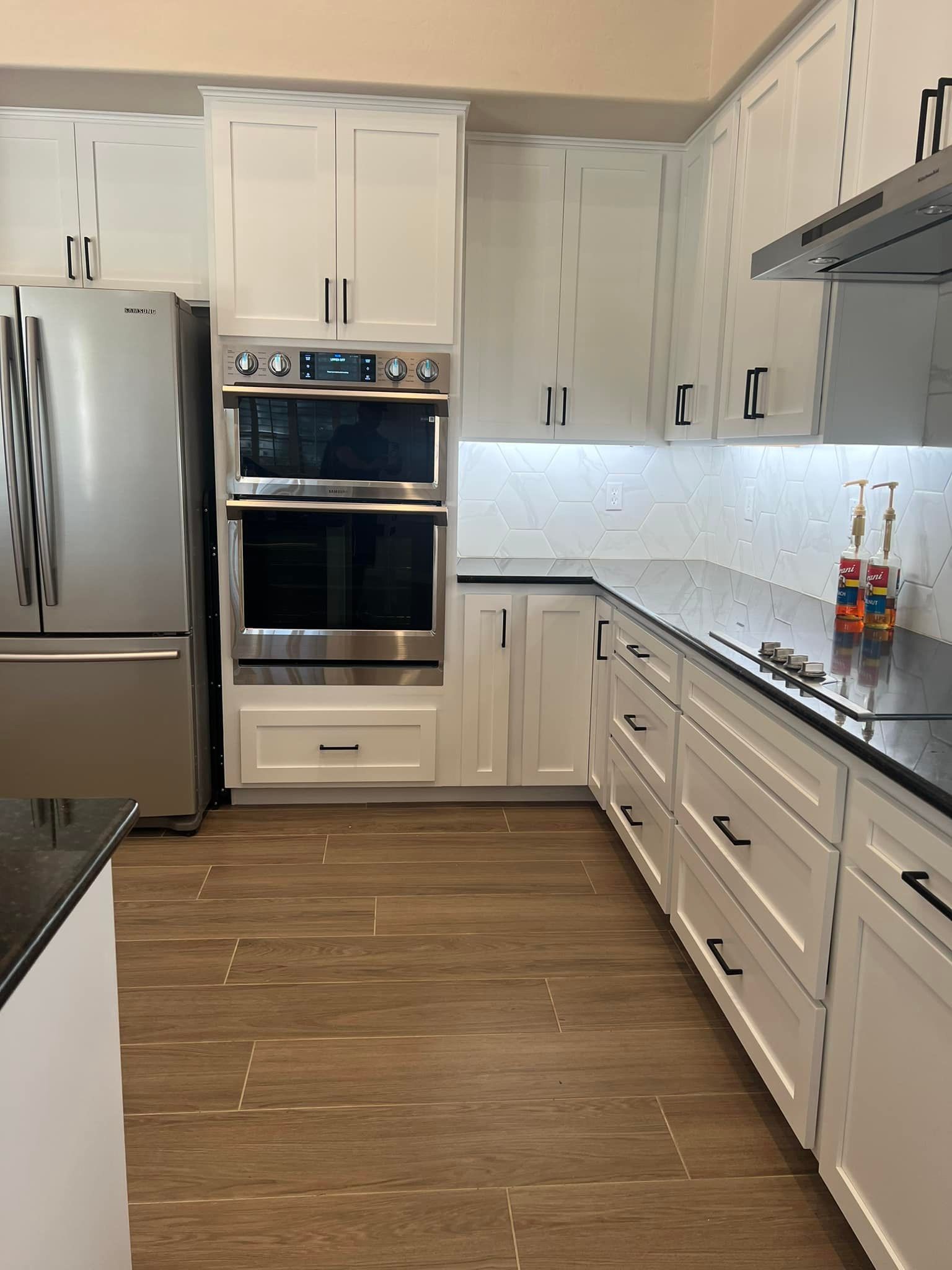 A kitchen with white cabinets and stainless steel appliances.