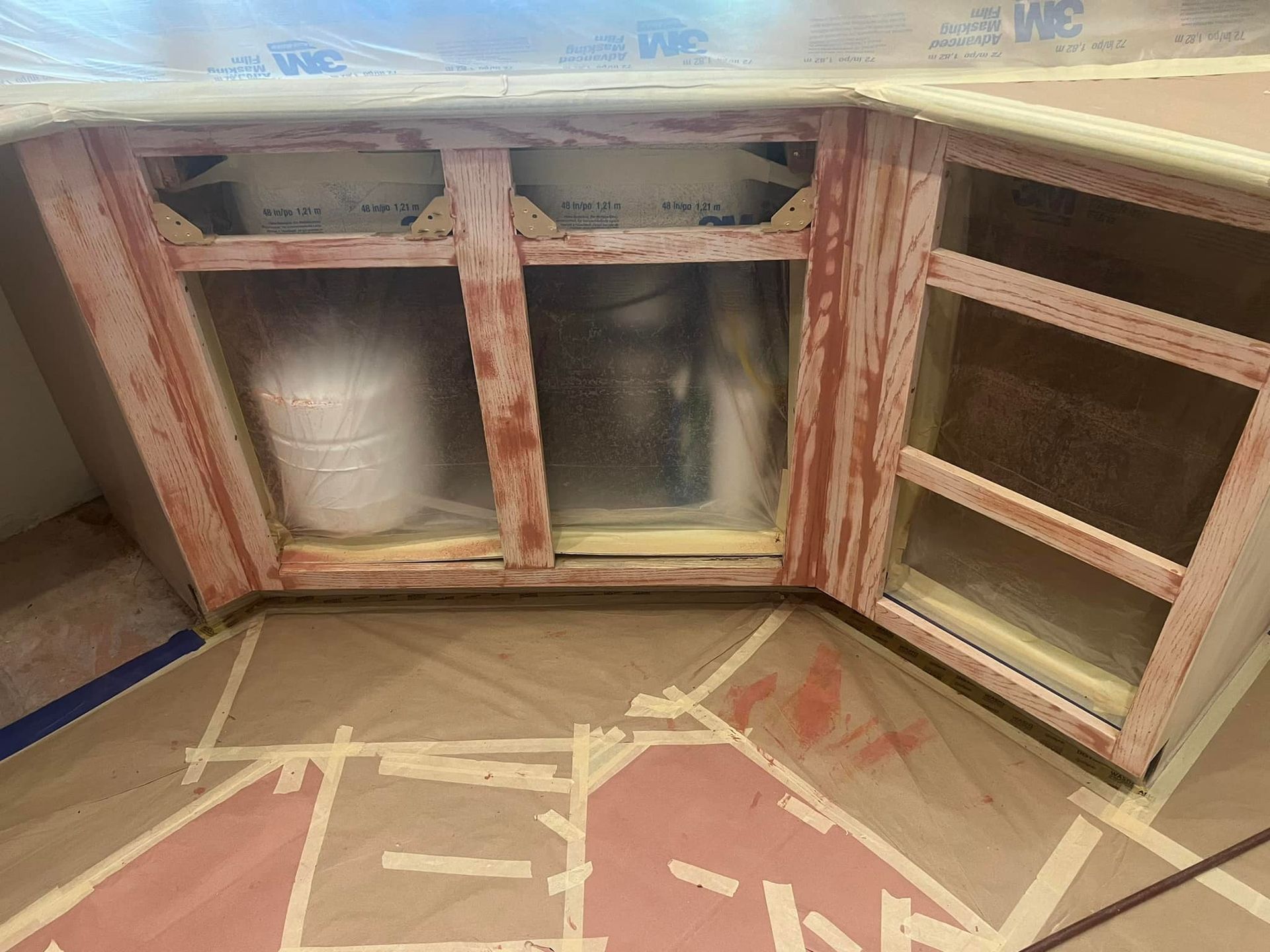 A kitchen cabinet is being painted red and white.