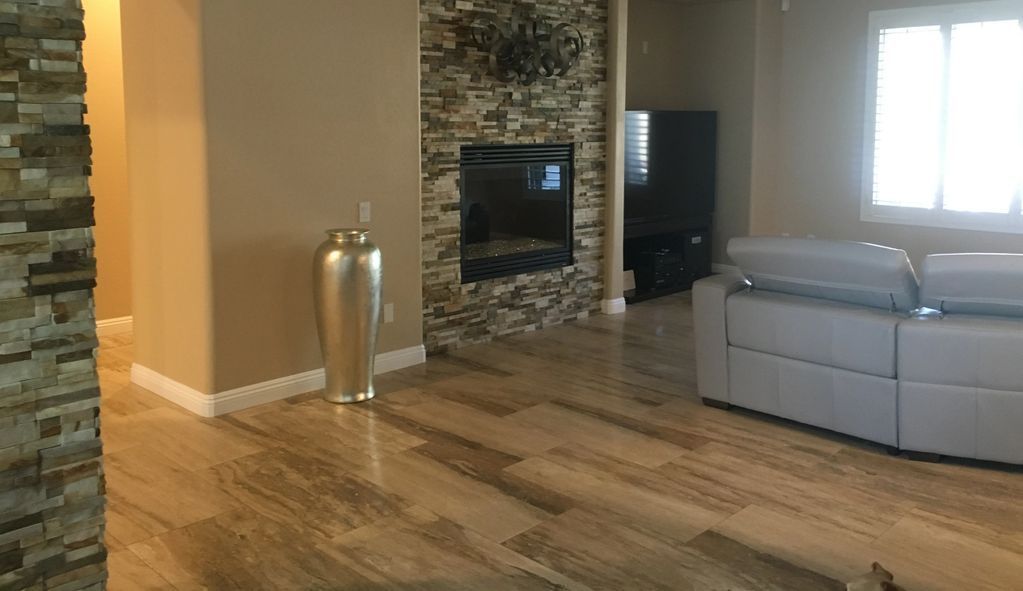 A living room with a couch , fireplace and vase.