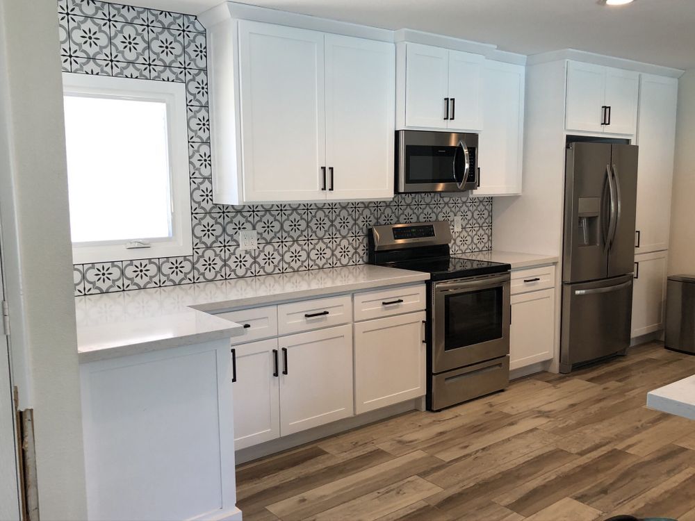 A kitchen with white cabinets and stainless steel appliances.