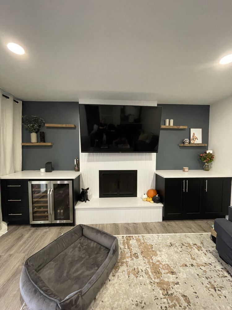 A living room with a fireplace , television , and a dog bed.