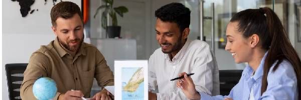 A group of people are sitting around a table looking at a map.