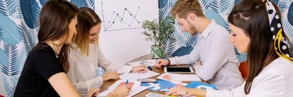 A group of people are sitting around a table having a meeting.