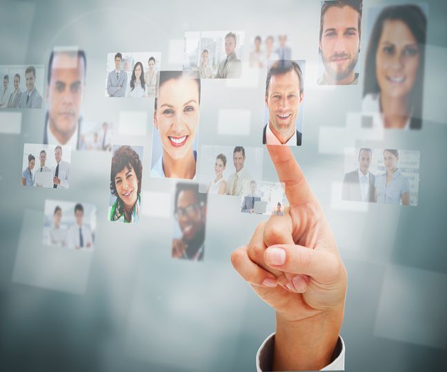 A hand is pointing at a group of people on a screen.