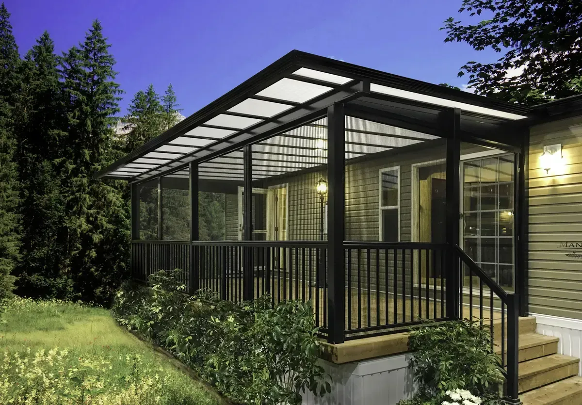 Covered porch with black railings, clear roof panels, on a home with a green lawn.