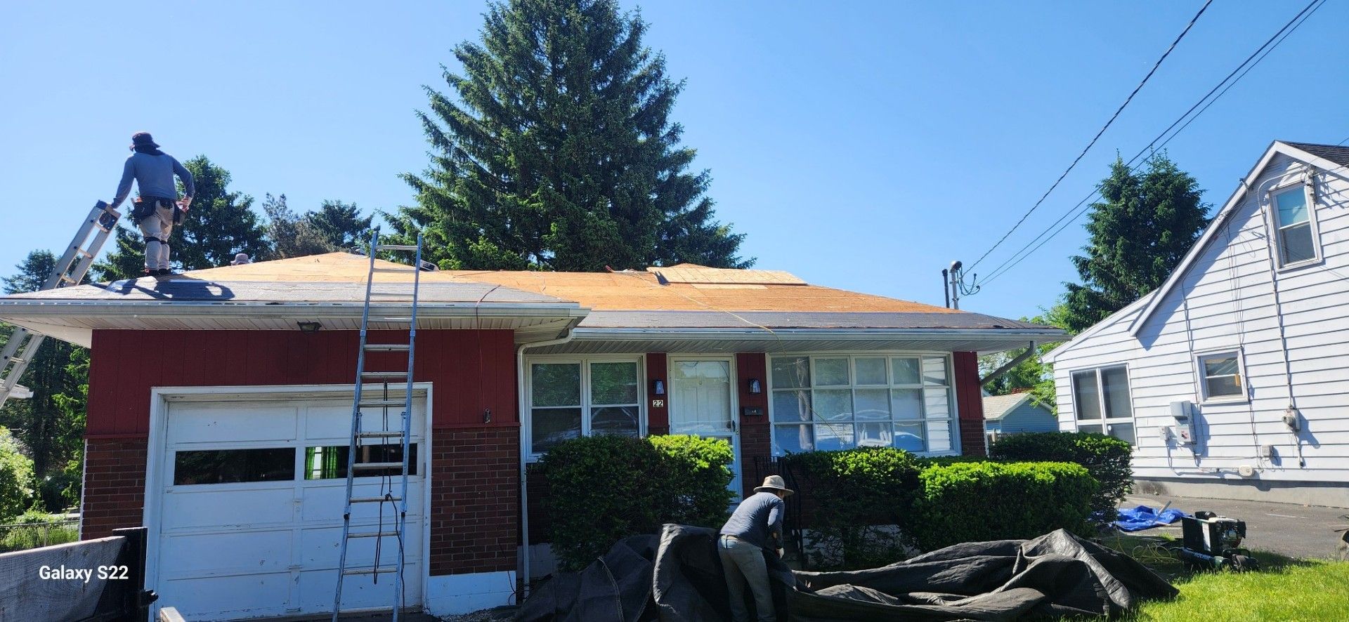 A man is working on the roof of a house.