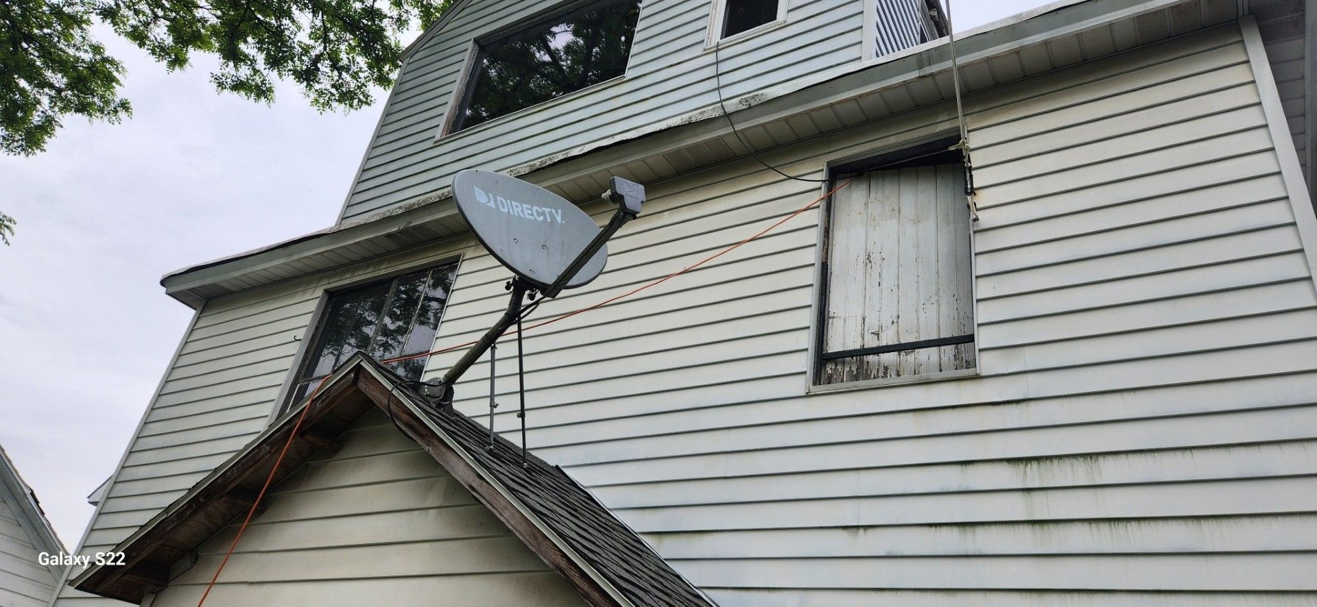 A white house with a satellite dish on the roof