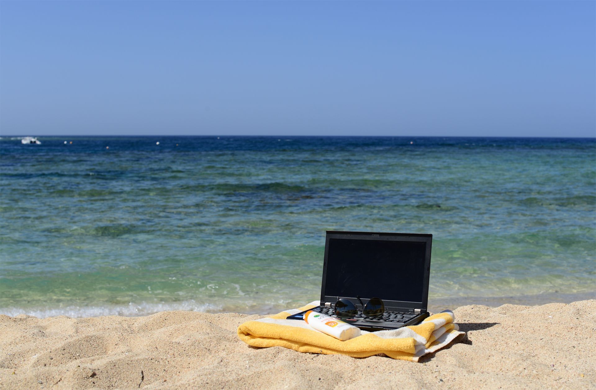 Laptop by the sea working from the beach