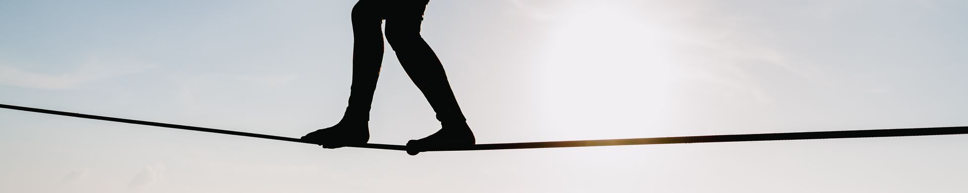 Silhouette on someone walking a tightrope 