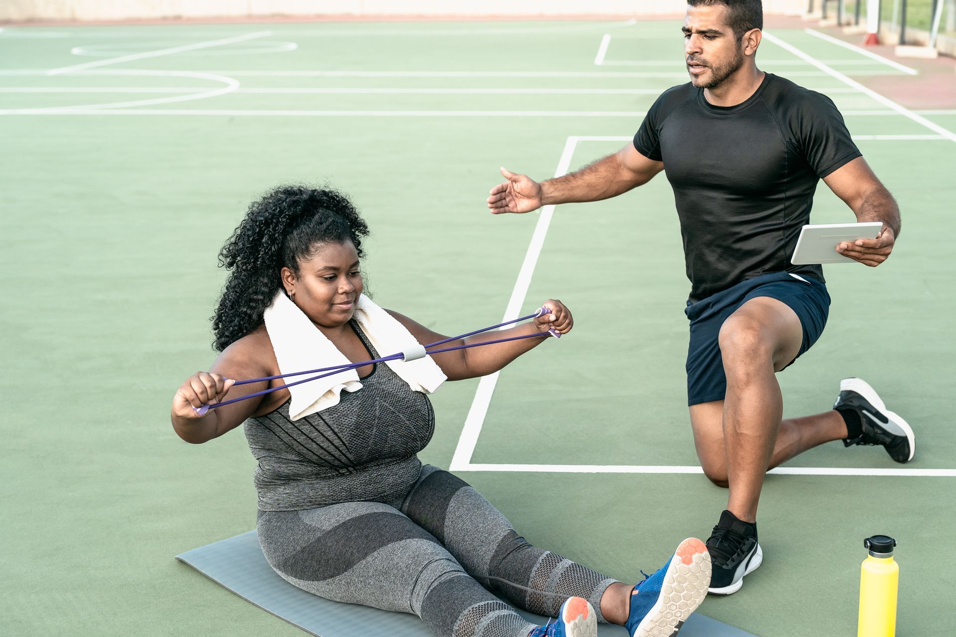 Plus sized woman being trained by a PT
