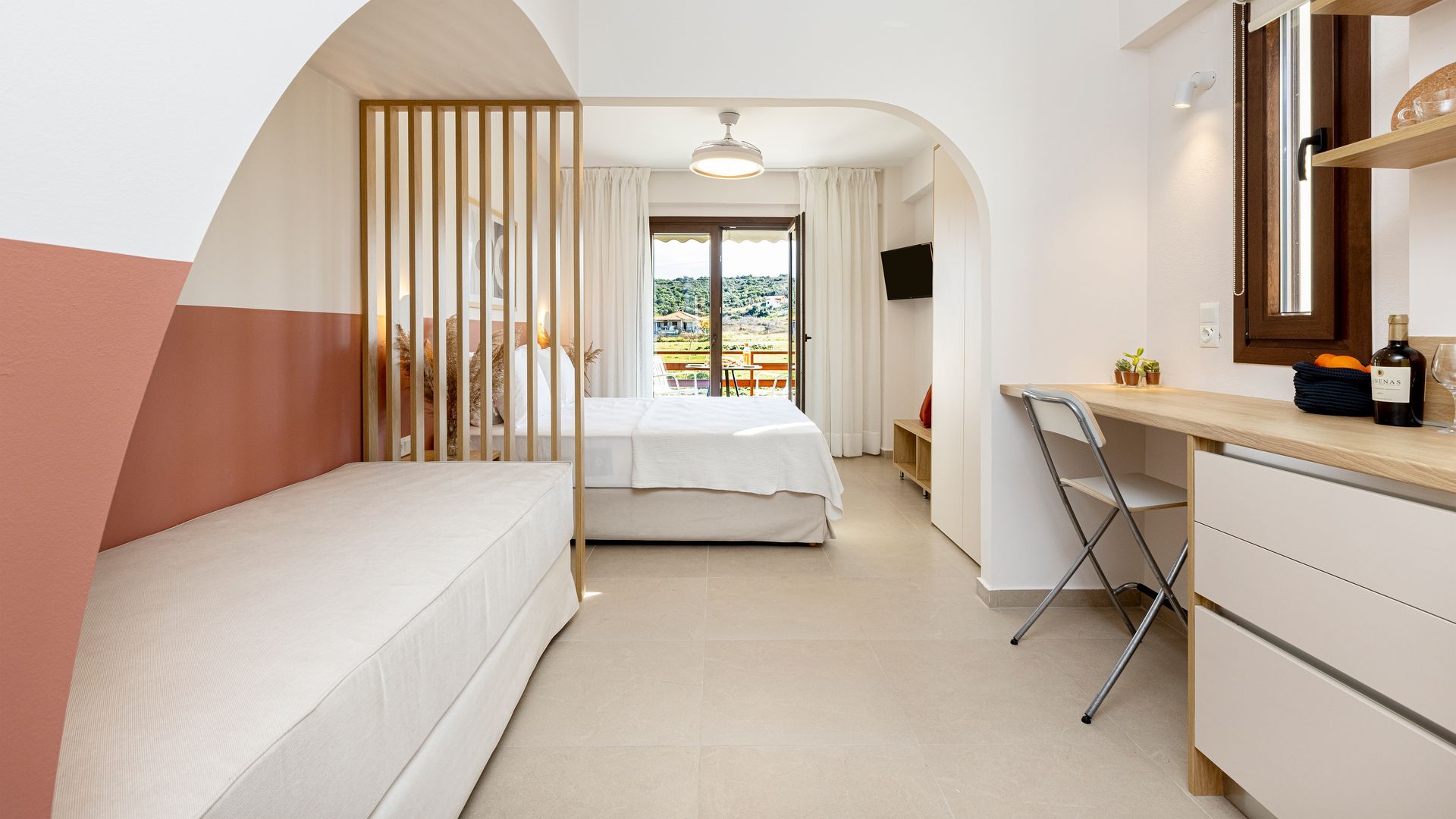 A bedroom with a bed , desk , chair and sliding glass doors.