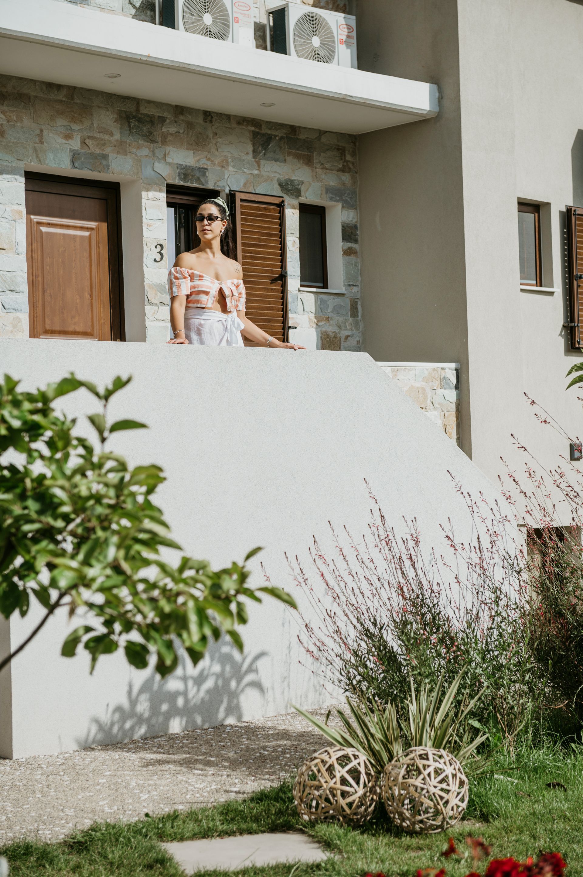 A woman is standing on a balcony of a building.