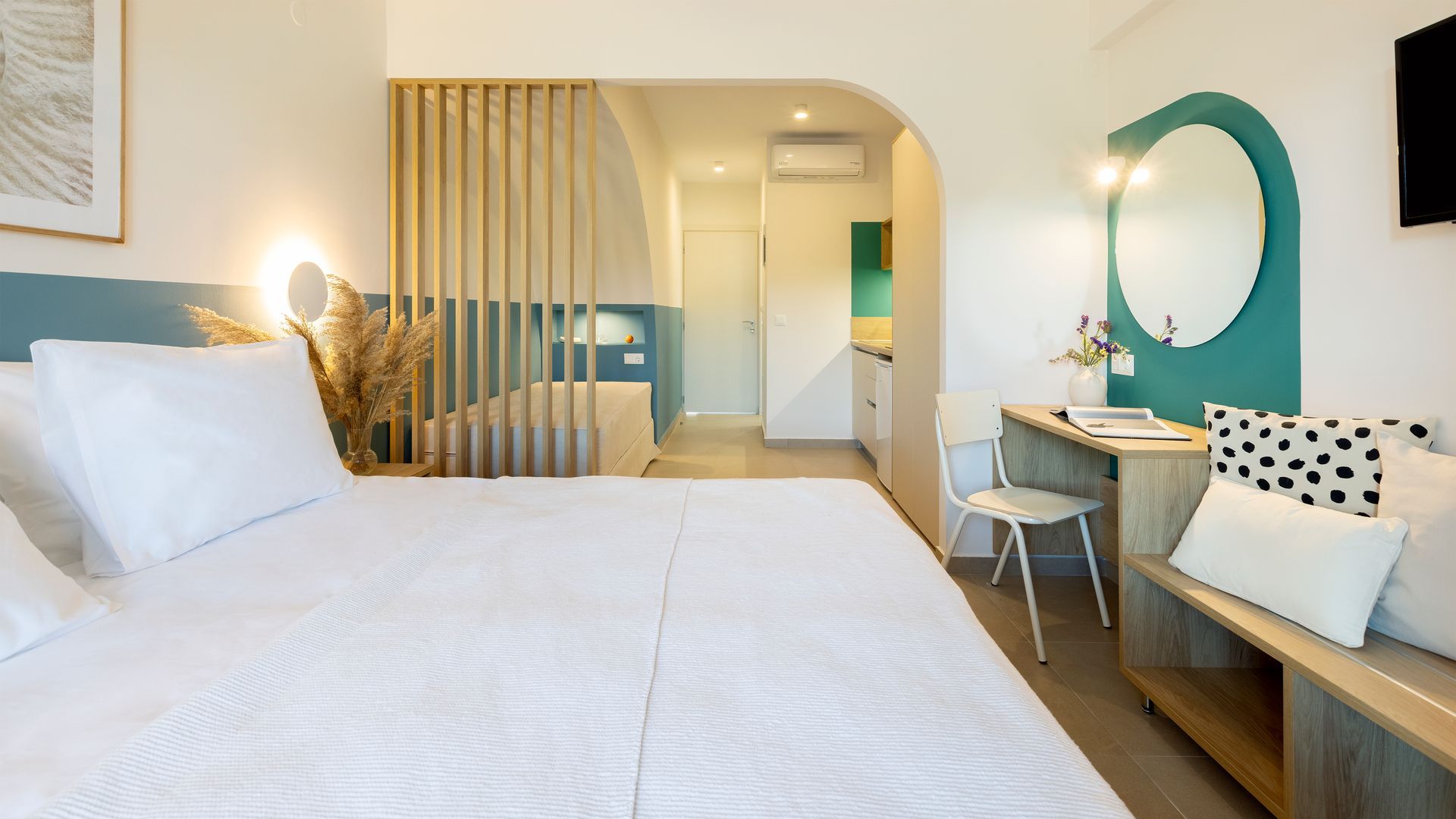 A hotel room with a bed , desk , chair and mirror.