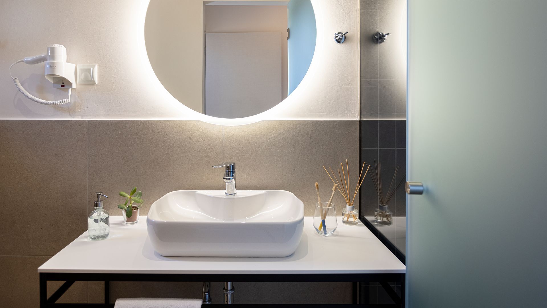 A bathroom with a sink , mirror and shower.