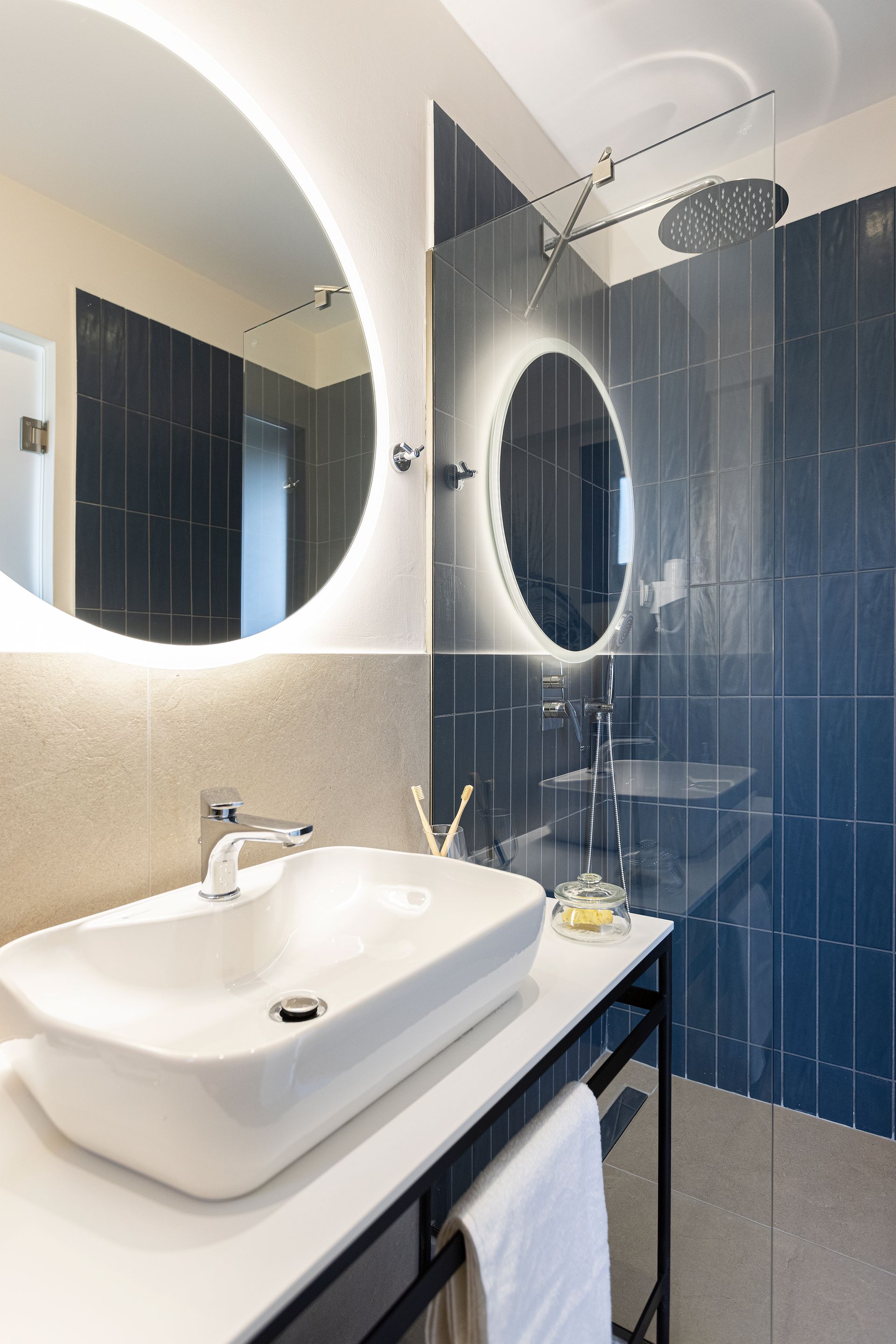 A bathroom with a sink , mirror and shower.