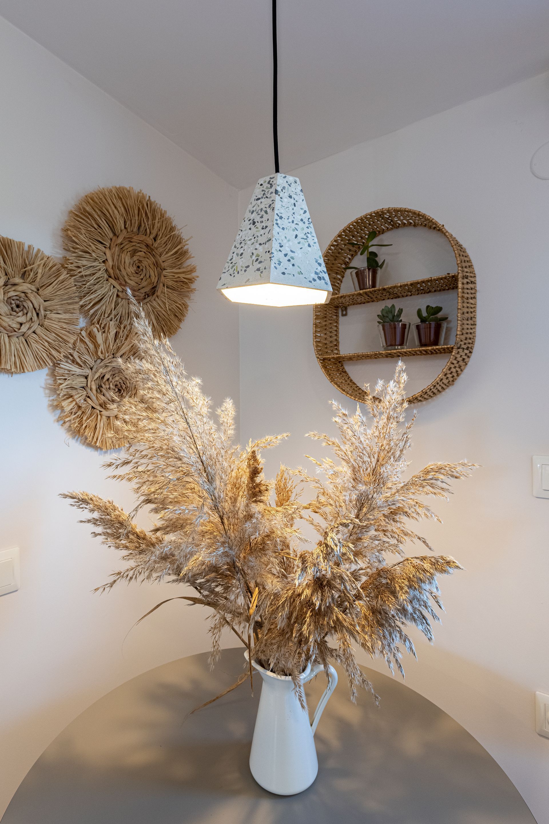A vase of dried flowers is sitting on a table in a room.