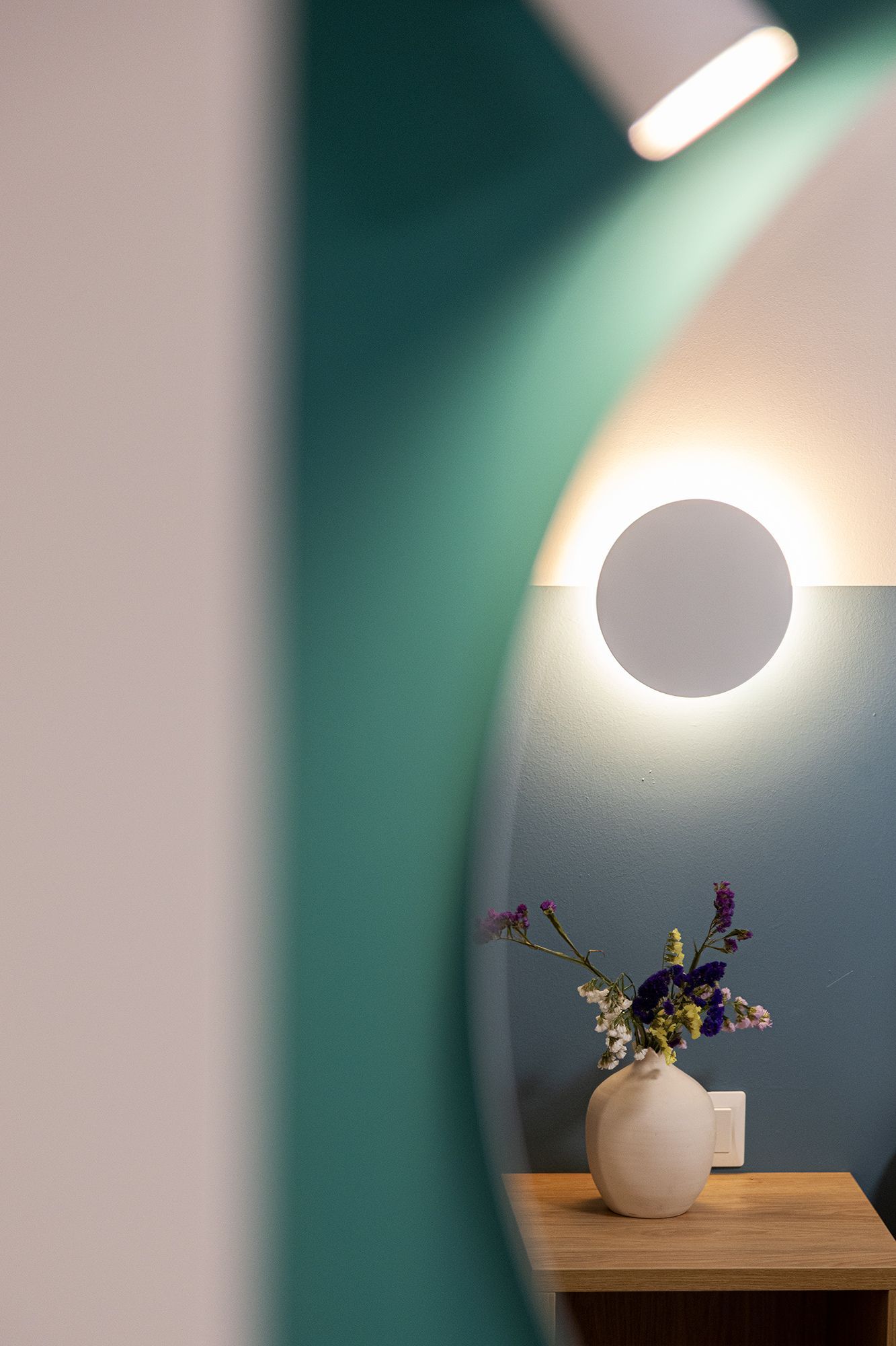 A vase of flowers is sitting on a table in front of a mirror.