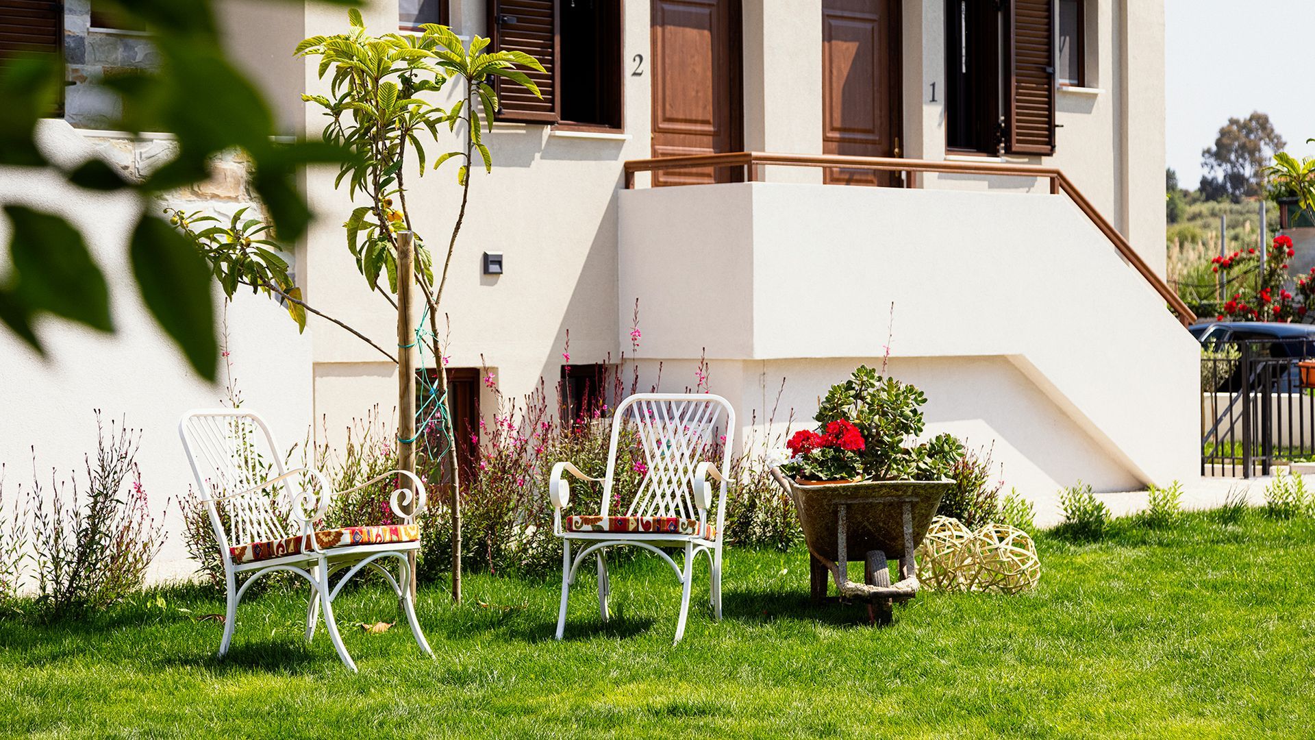A white house with a wheelbarrow in front of it