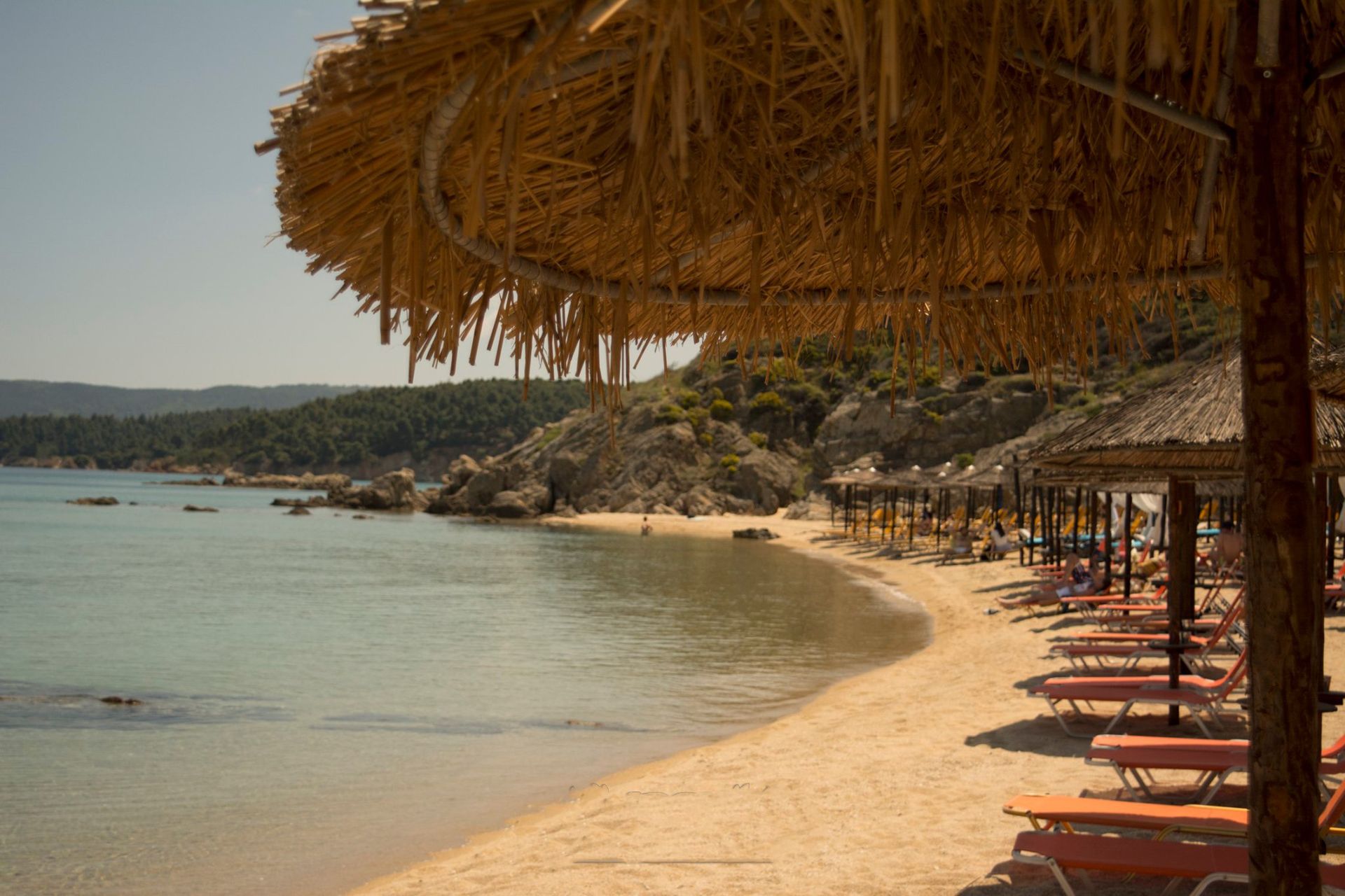 A beach with a lot of chairs and umbrellas on it.