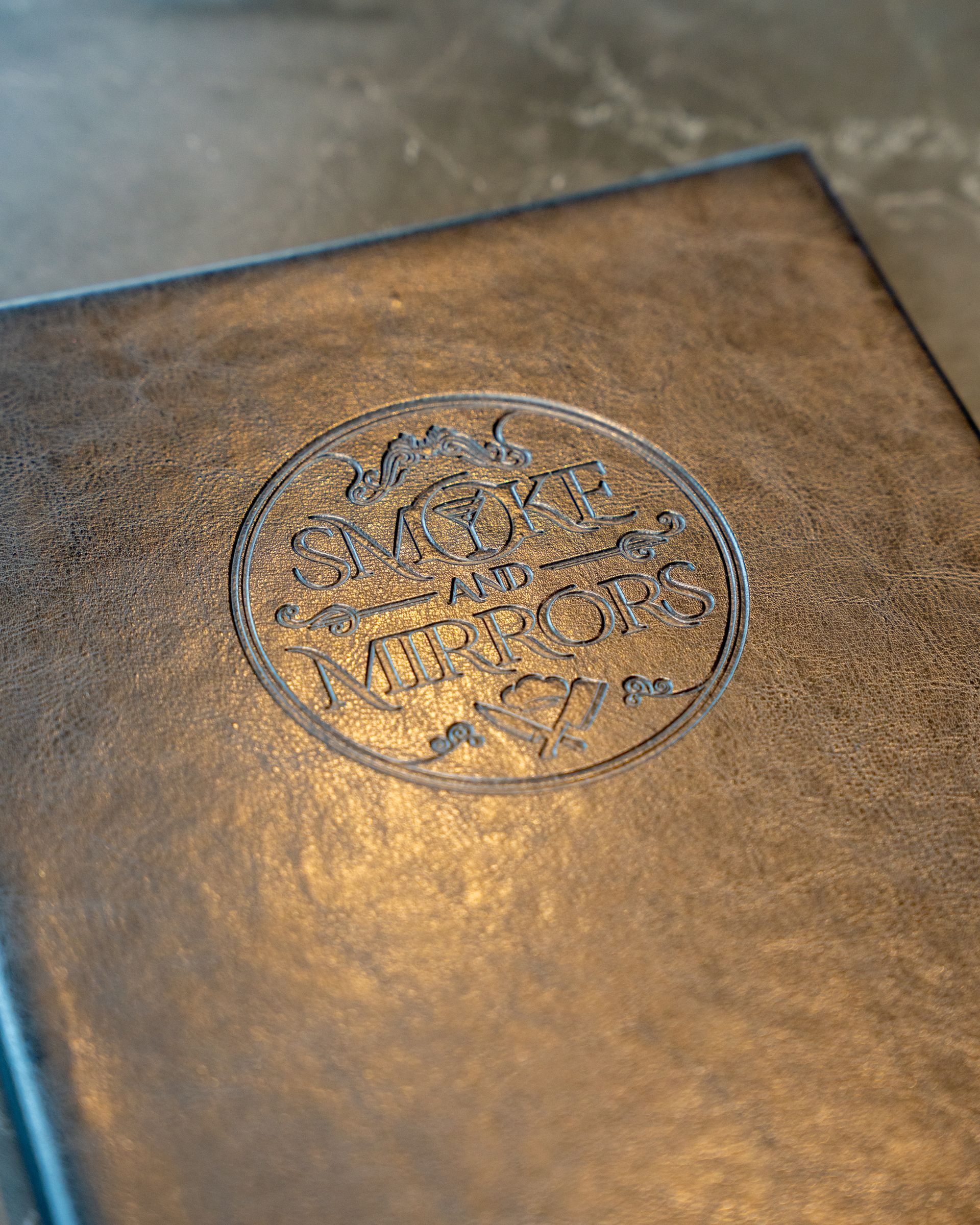 Brown leather book with embossed circular design.