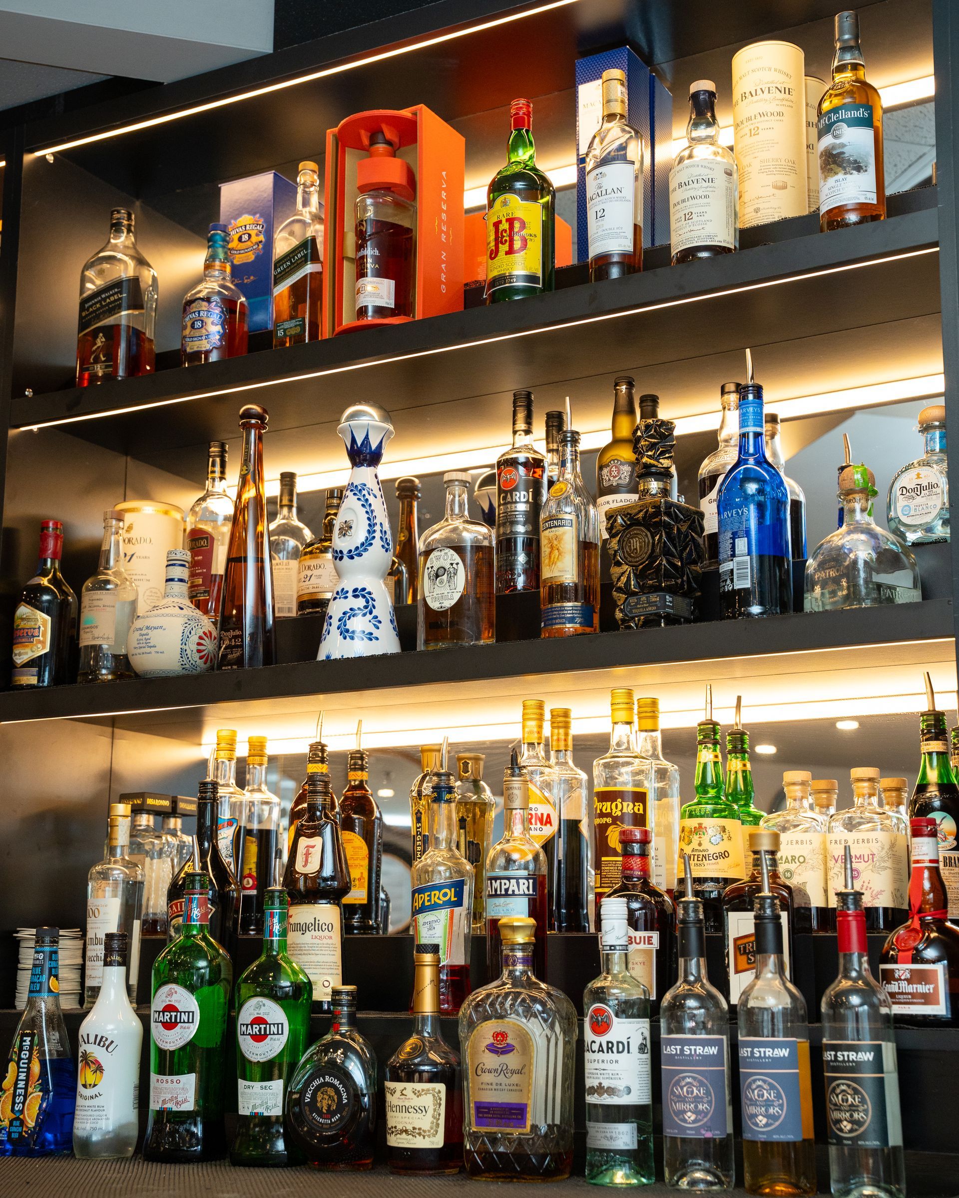 Bar shelves stocked with various liquor bottles.