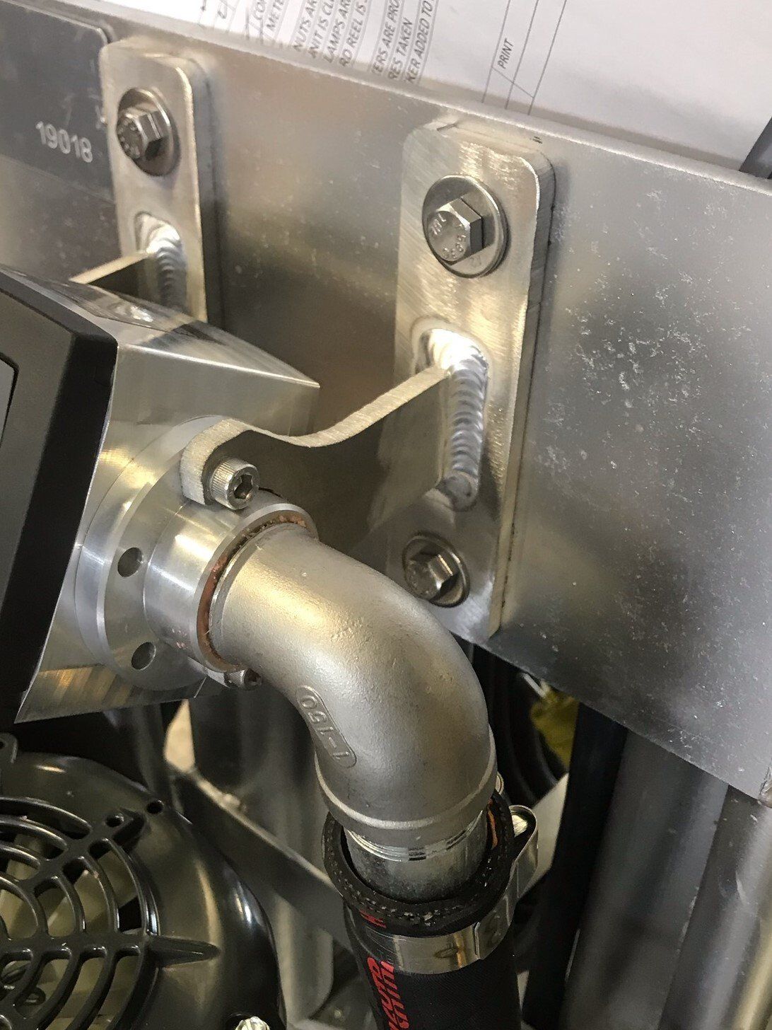 A close up of a metal pipe with a hose attached to it.