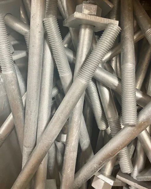 A pile of metal screws and bolts are stacked on top of each other.