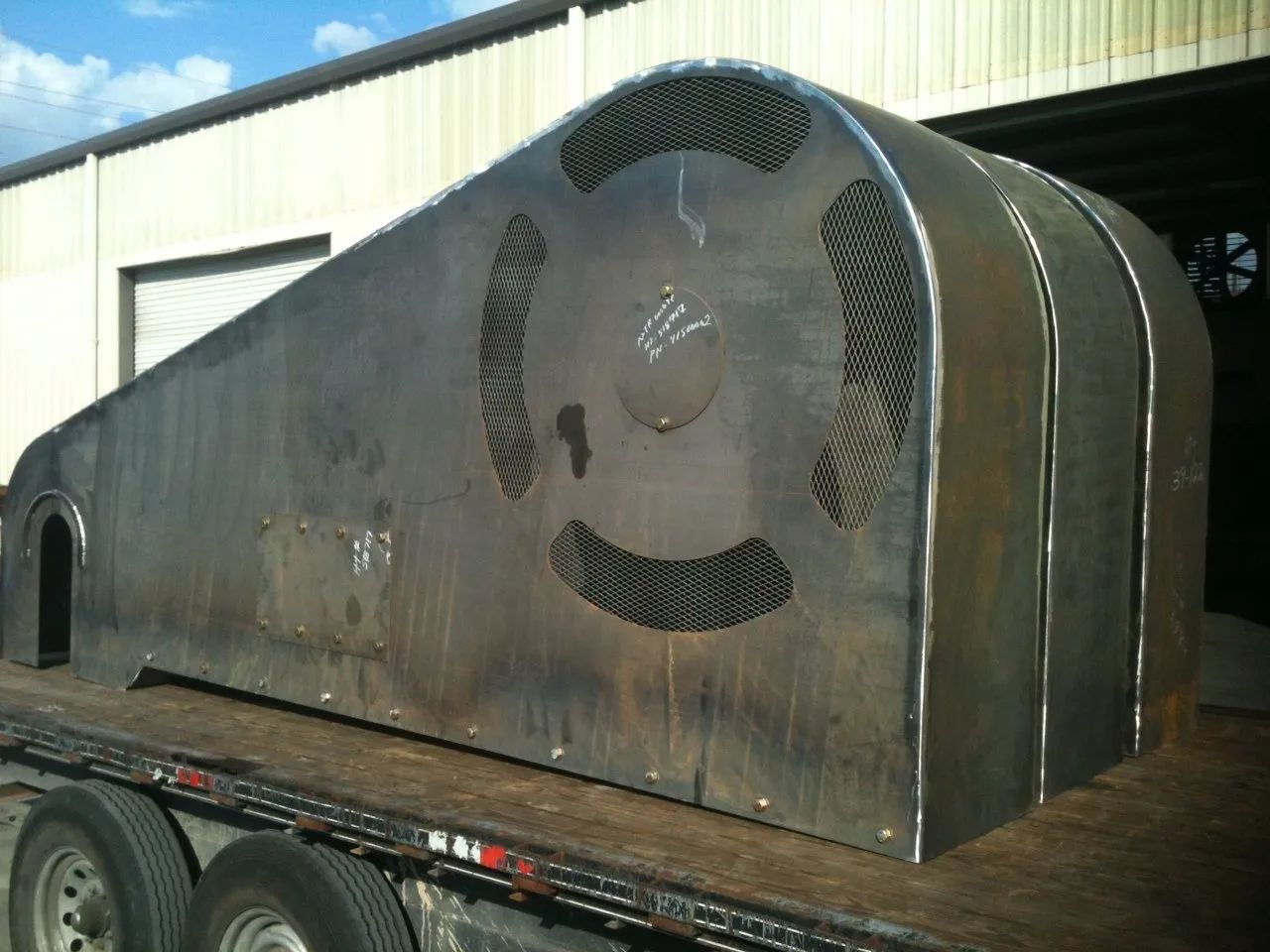 A large metal object is sitting on top of a trailer