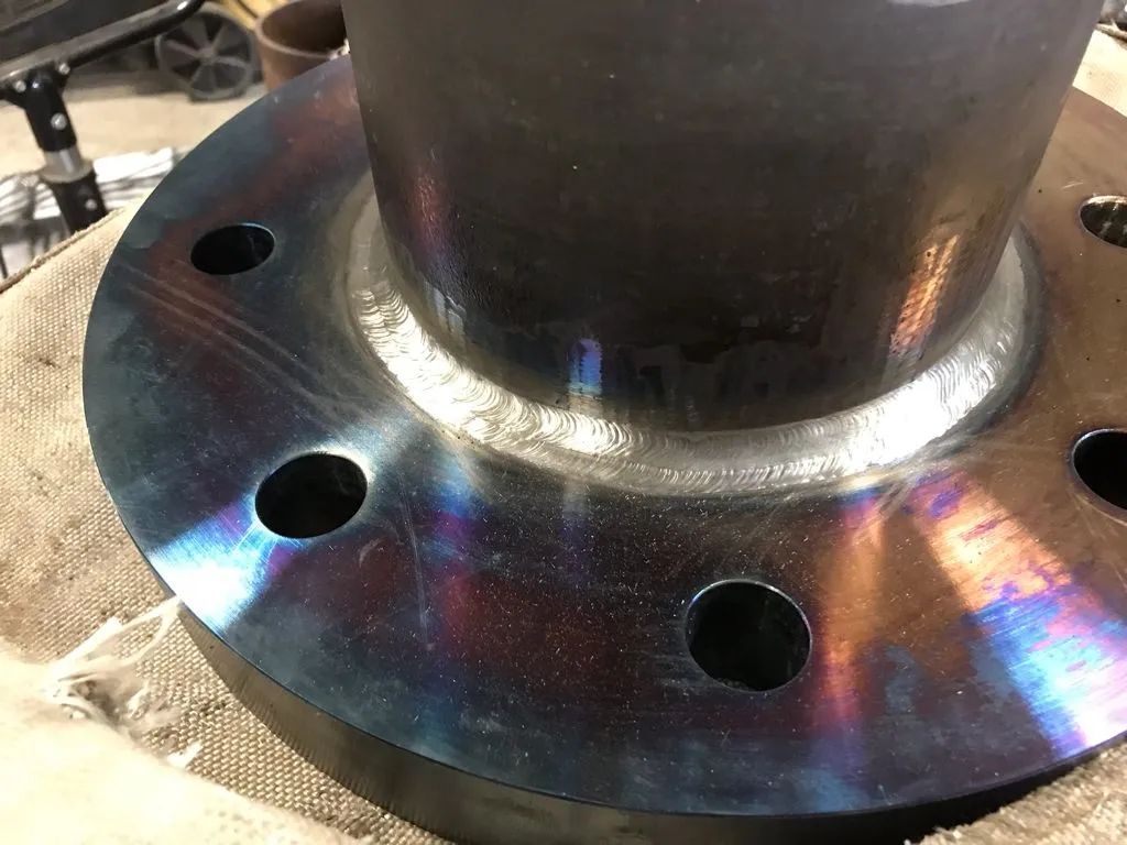 A close up of a metal flange with holes in it.