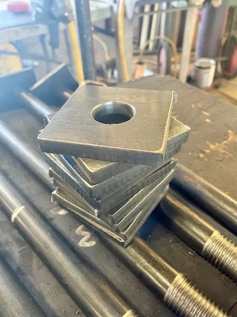 A stack of metal plates with holes in them are sitting on top of each other on a table.