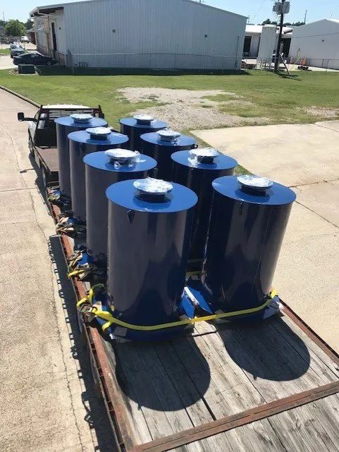 A truck with a bunch of blue cylinders on it