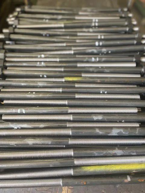 A bunch of metal rods are stacked on top of each other on a table.