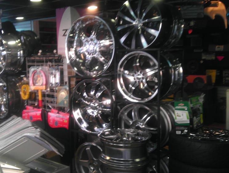 A bunch of chrome wheels are stacked on top of each other