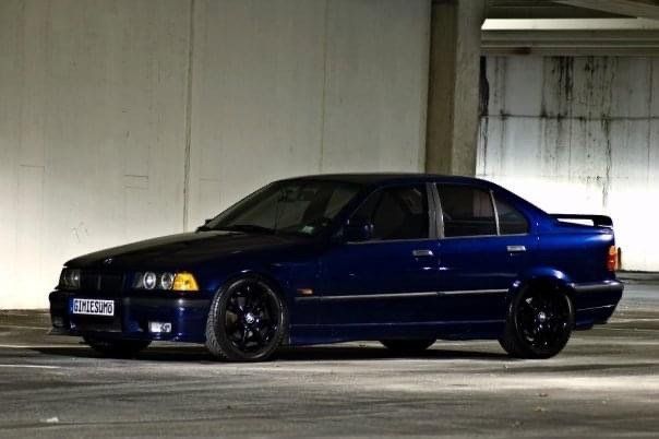 A blue bmw is parked in a parking garage