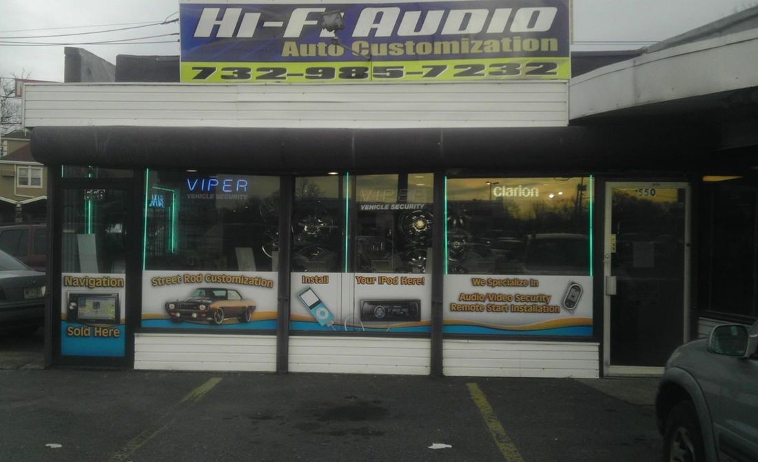 A car is parked in front of a hi-fi audio auto customization store