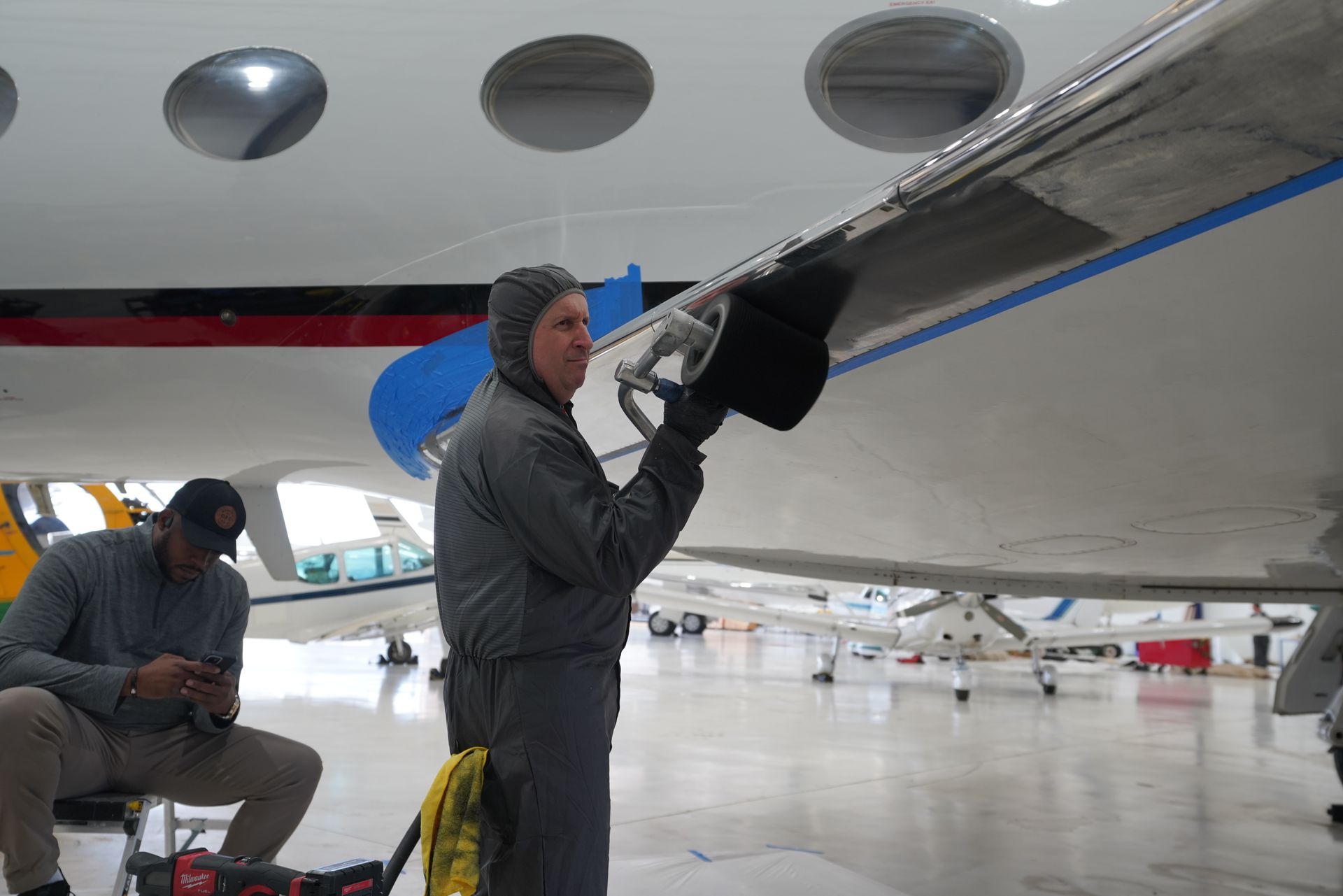 Technician polishing aircraft metal at Jacksonville Executive Airport