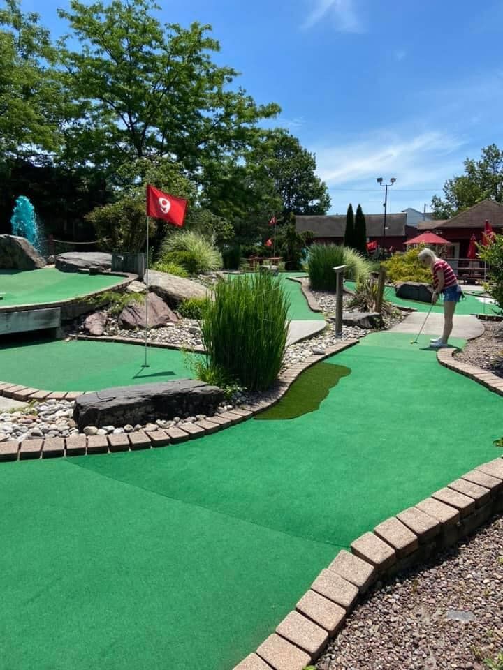 A person is playing a game of mini golf