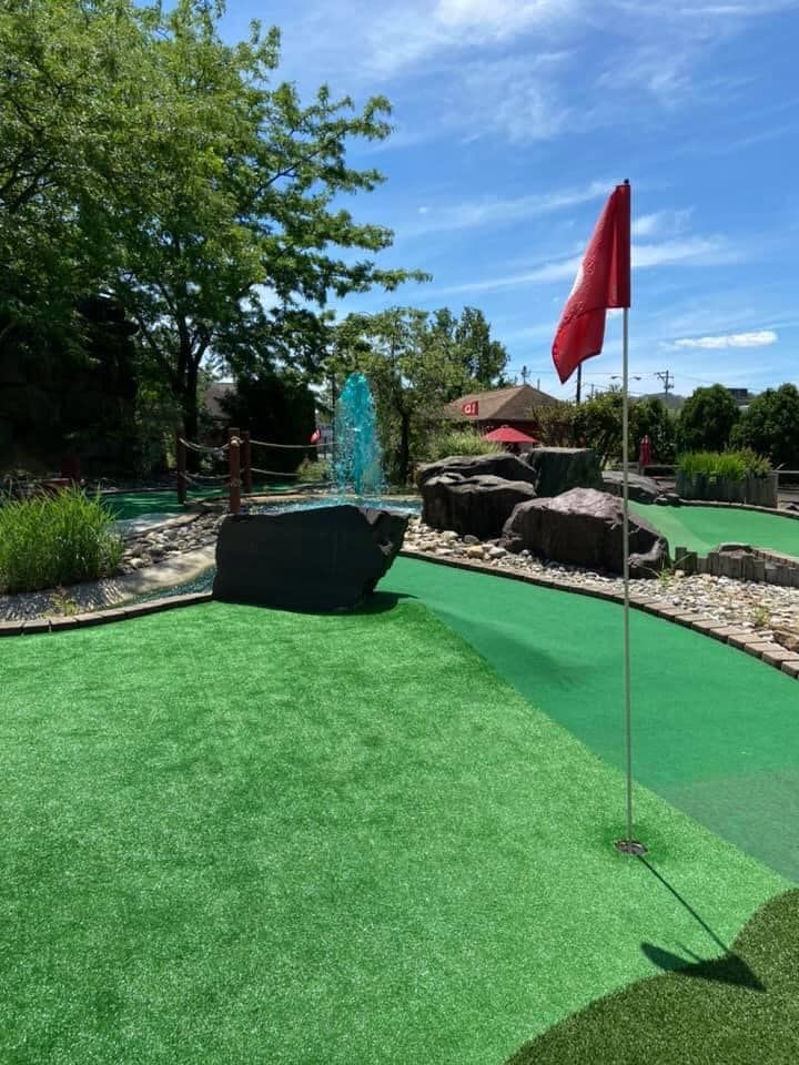 A golf course with a red flag on the green