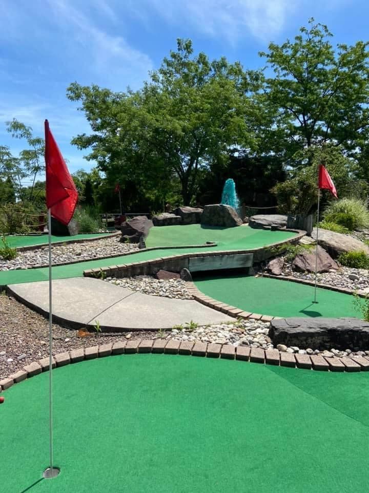 A golf course with a red flag on the green
