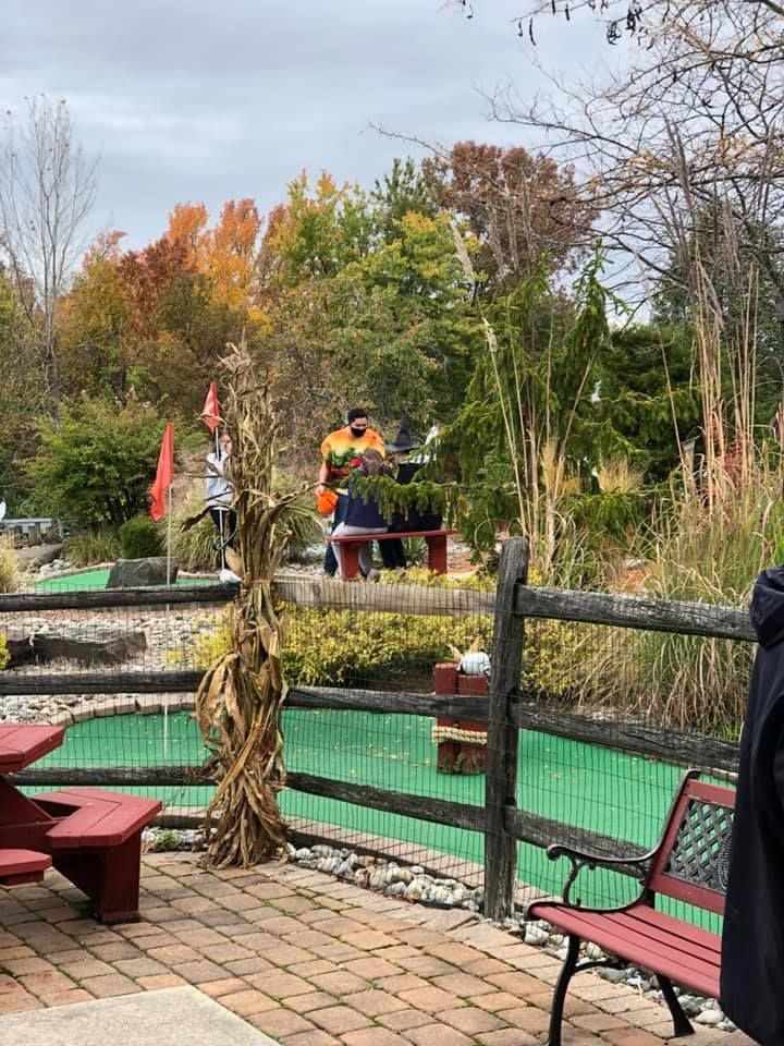 A man is standing in front of a picnic table in a park.