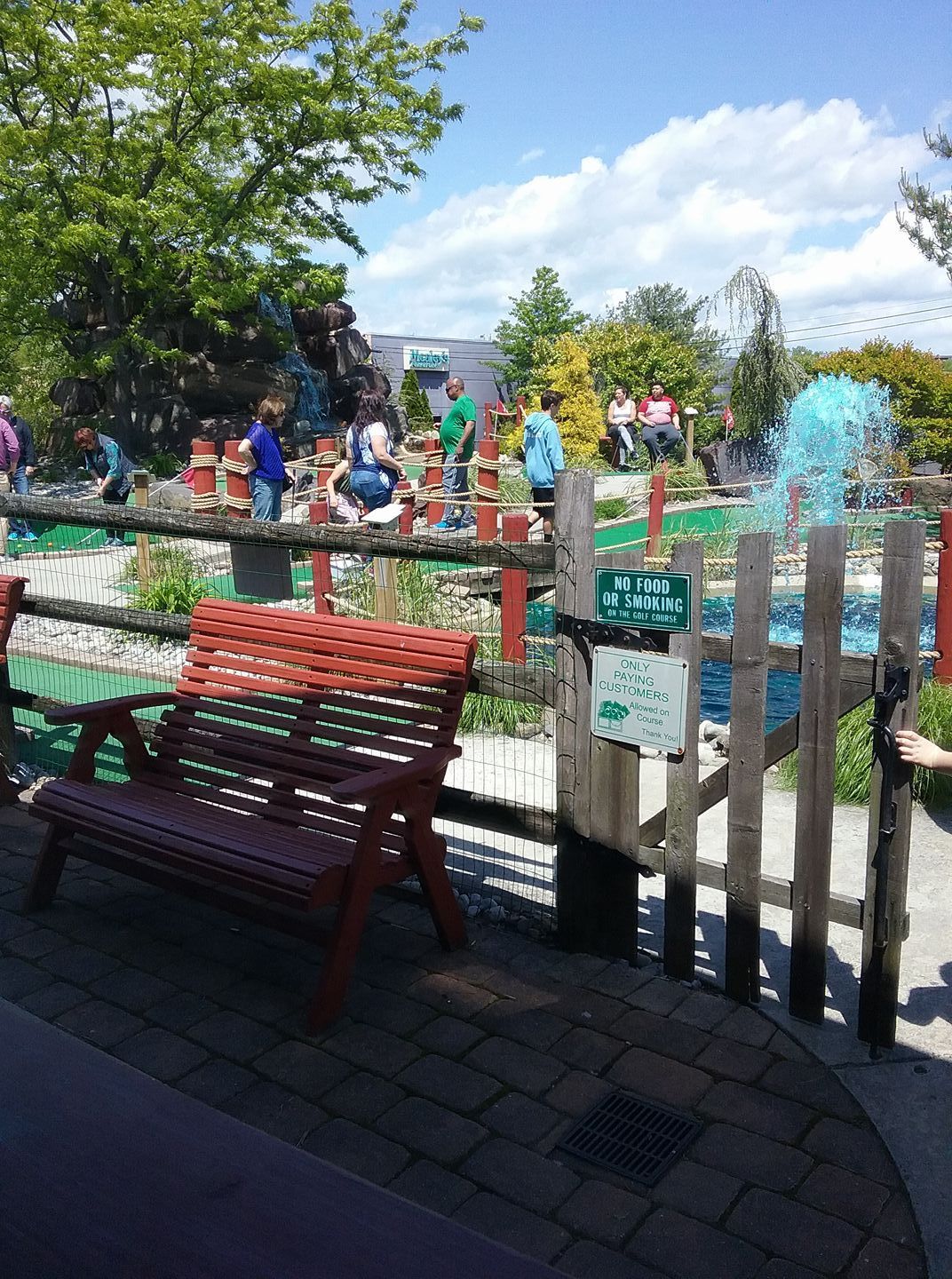A group of people are playing in a mini golf course.