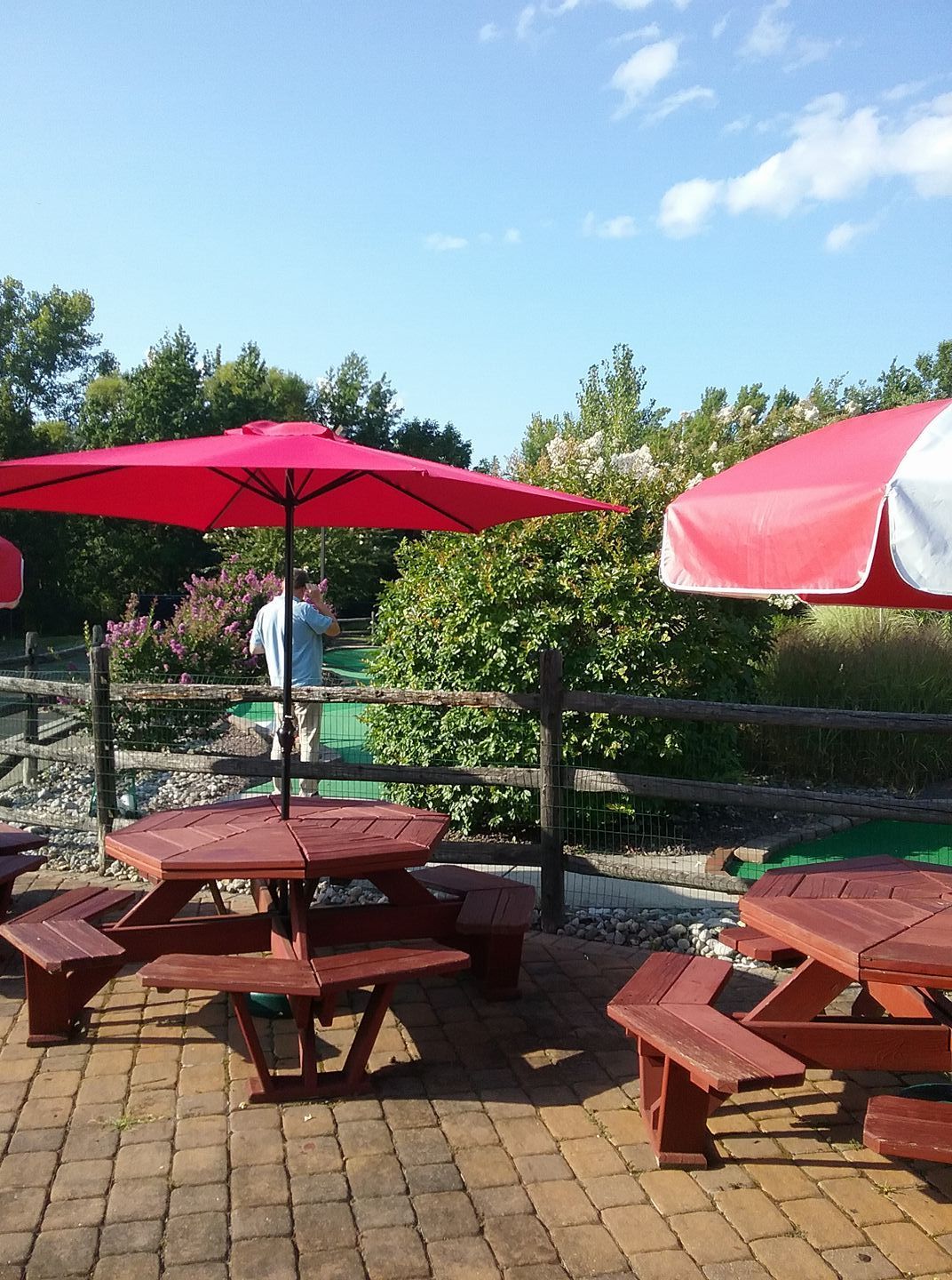 A group of picnic tables with red umbrellas