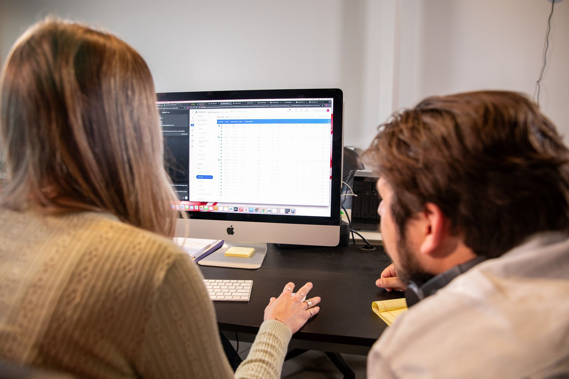 Two people, woman and man, looking at a computer screen together at a desk.
