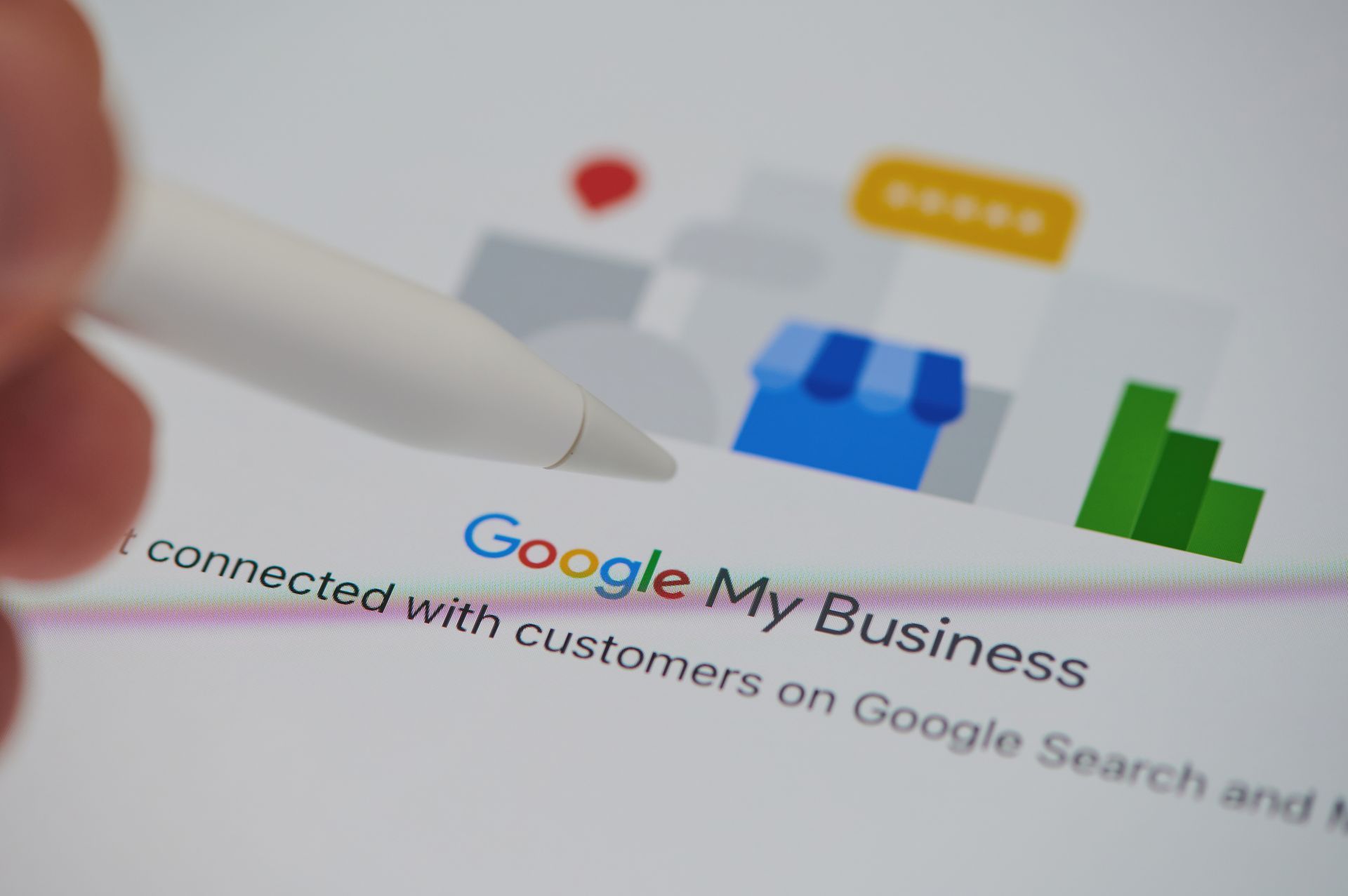 Person using a stylus to point at the Google My Business logo on a tablet screen.