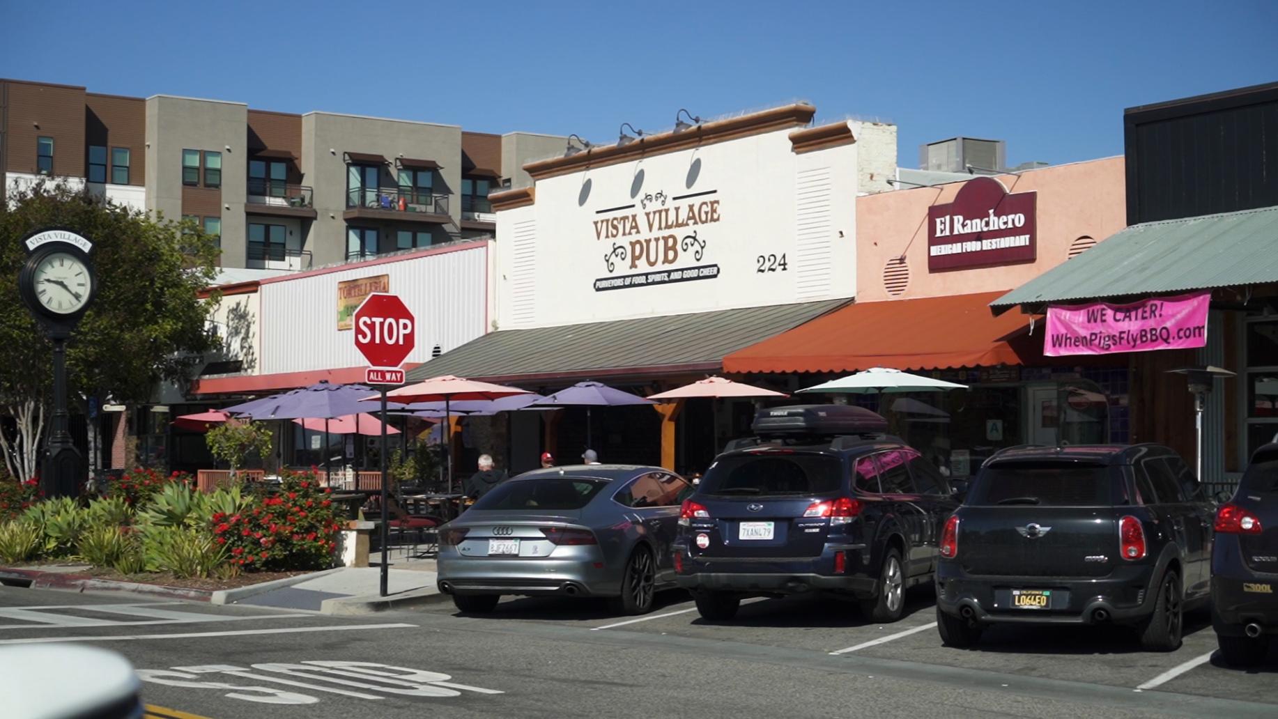 Cars are parked in front of a building with a stop sign
