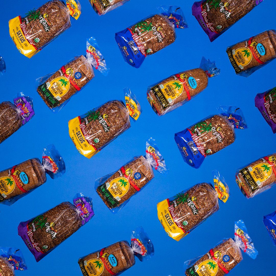 A bunch of bags of bread are lined up on a blue background