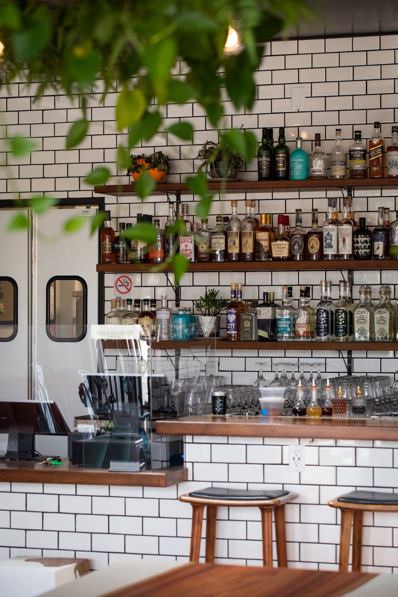 a fancy restaurant bar with lots of glass bottles on a shelf