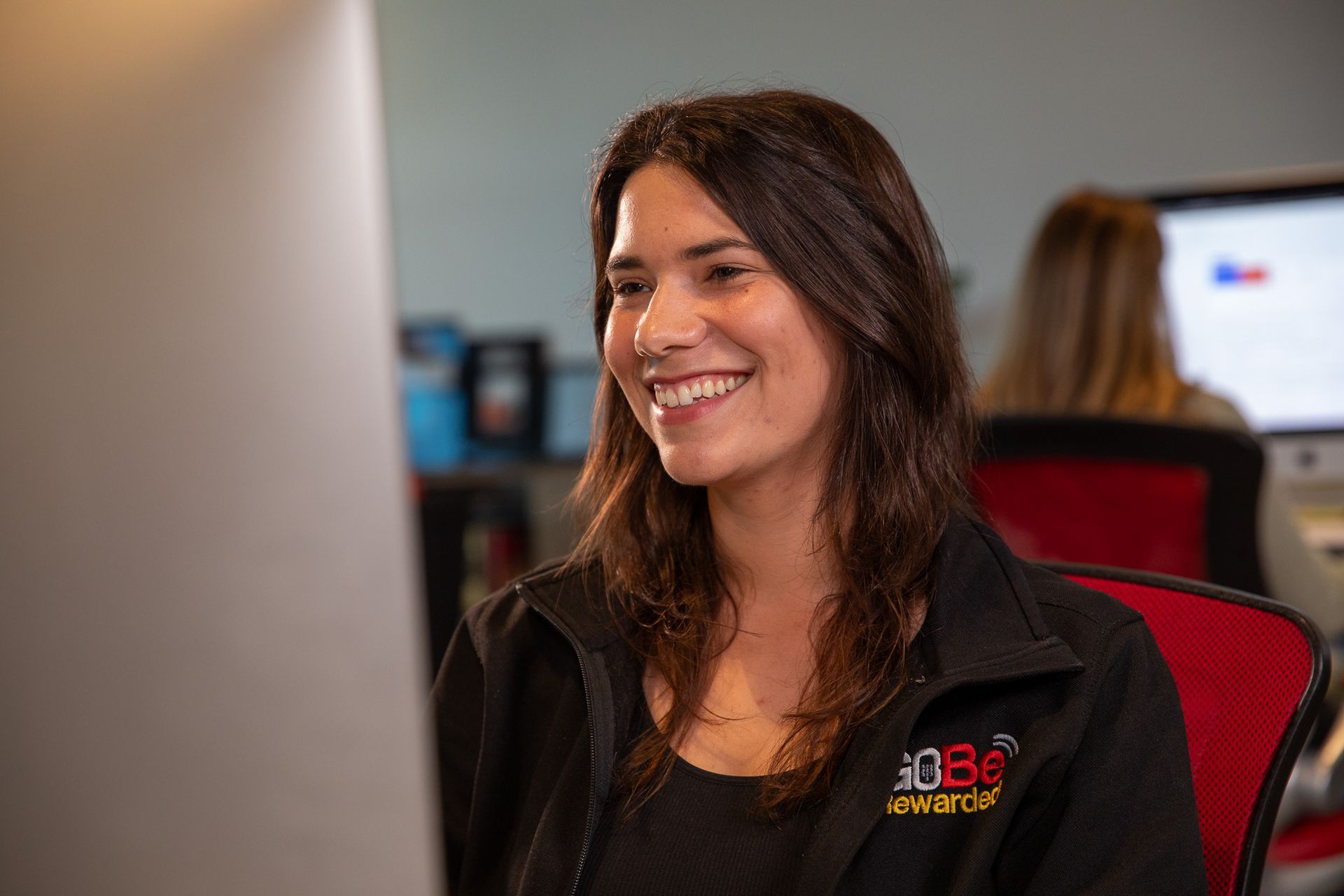 A man is sitting at a desk talking on a phone