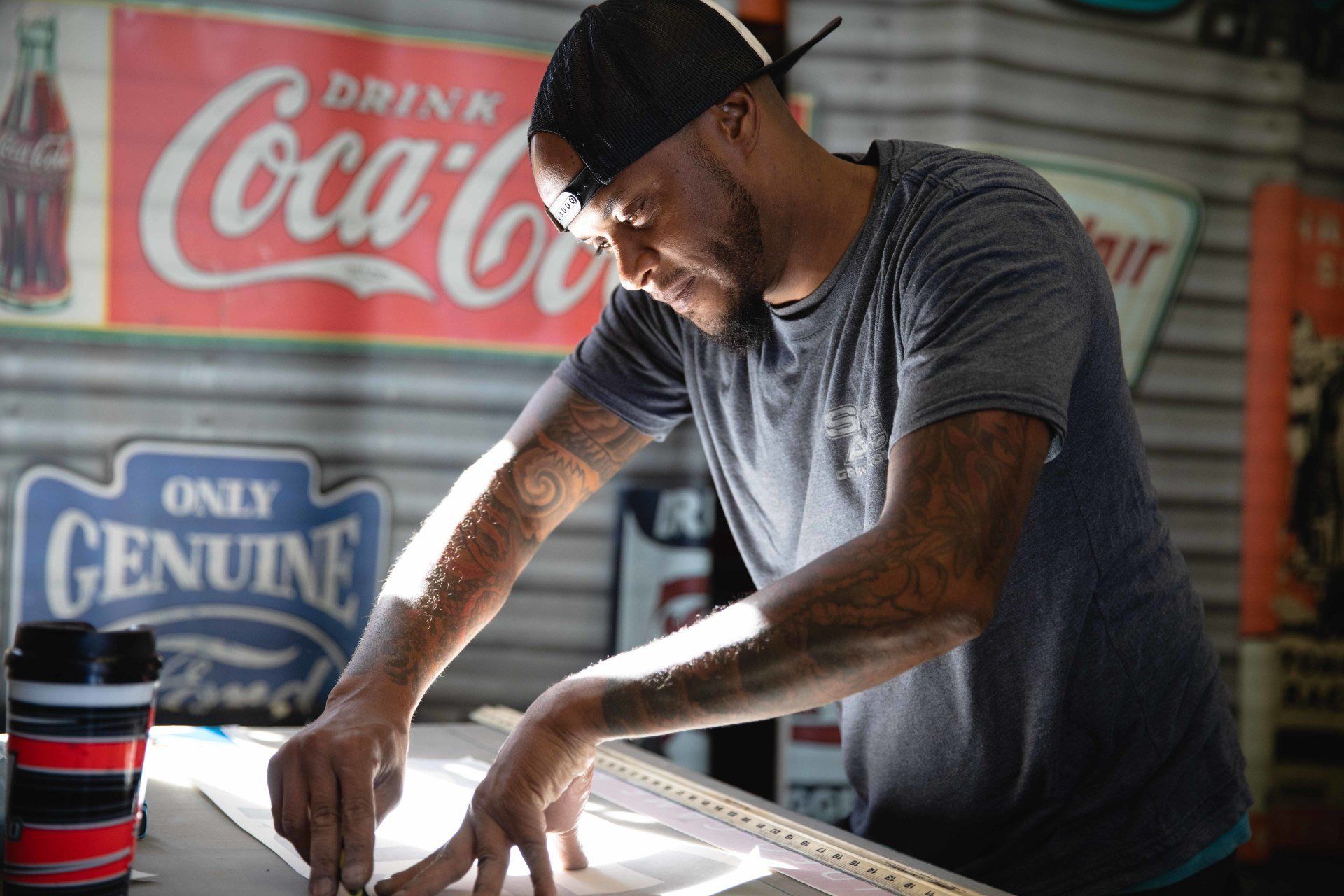 A man is working in front of a coca cola sign